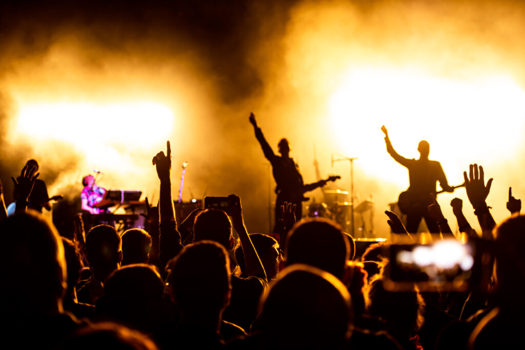 Shot of a crowd on a concert while the band is playing on the stage